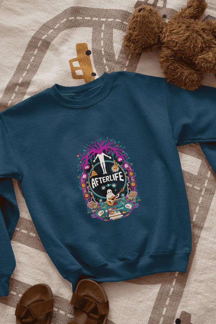 Navy Blue sweatshirt featuring a colorful graphic design with a circular Afterlife text, showing a person with outstretched arms standing in front of a tree with pink and purple leaves. The design includes a light blue sky with white clouds, a person in a blue shirt smiling, and brown sandals and a teddy bear on a beige and white patterned blanket.