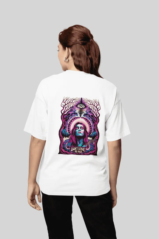 A white oversized t-shirt with a graphic design on the back featuring a woman in psychedelic colors (violet, magenta, turquoise). She is serene, surrounded by ornate floral patterns and the text “DON’T LEAVE ME HIGH.” The style is pop art and vintage-inspired.