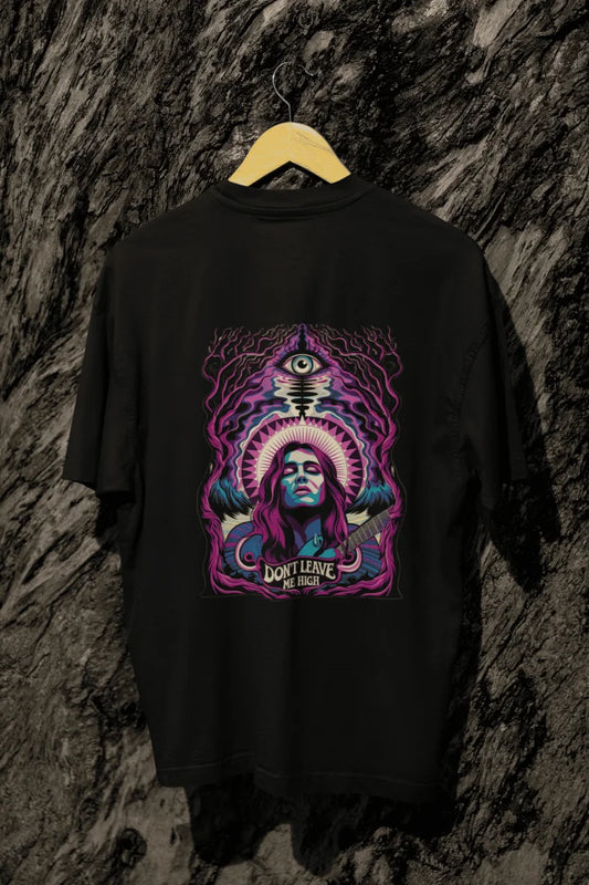 A black oversized t-shirt with a graphic design featuring a woman with purple hair playing a guitar, surrounded by mystical foliage and an eye. The design includes the text “DON’T LEAVE ME HIGH” in bold, psychedelic colors like purple, blue, and pink.
