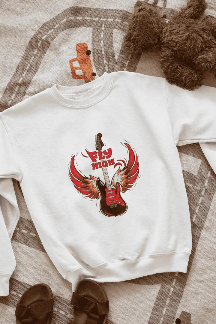 A white sweatshirt with a graphic design of a red electric guitar with fiery red wings, and the words “Fly High” in bold, red letters above it. The sweatshirt is laid flat on a beige-gray patterned rug with road markings, with brown sandals on either side. The lighting is soft and natural, giving the overall look a casual, fun style.
