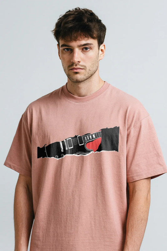 Man wearing a pink t-shirt with a graphic design on a light gray background