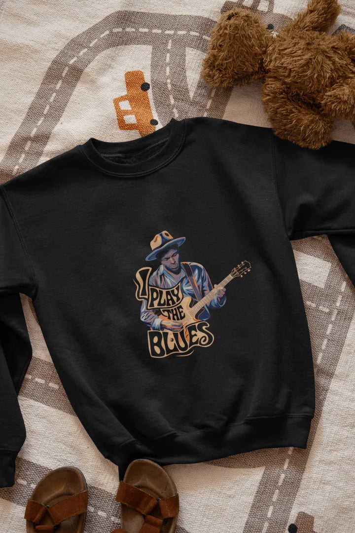 A black sweatshirt with the design of a man playing guitar. There’s a text on the design saying I play the blues.