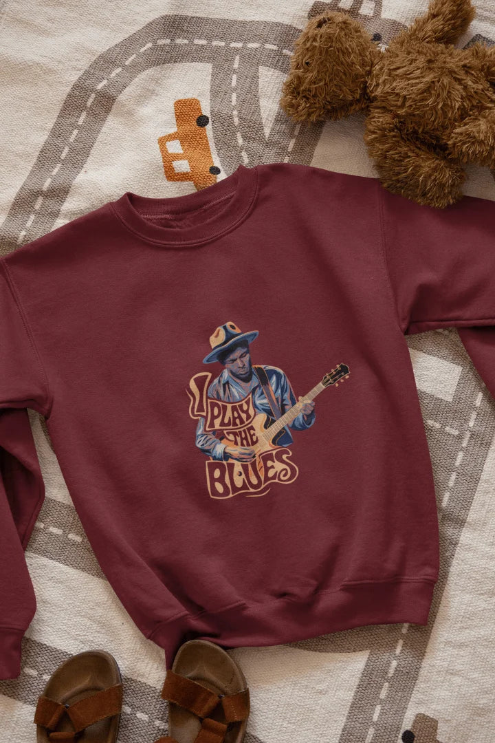 A maroon sweatshirt with the design of a man playing guitar. There’s a text on the design saying I play the blues.