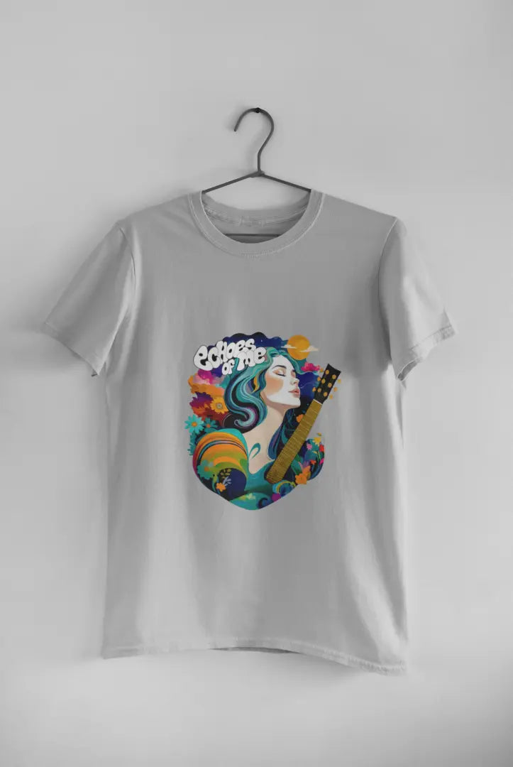 A grey T-shirt hanging against a grey background consisting of a psychedelic design of a girl holding a guitar. There’s a text saying echoes of me.