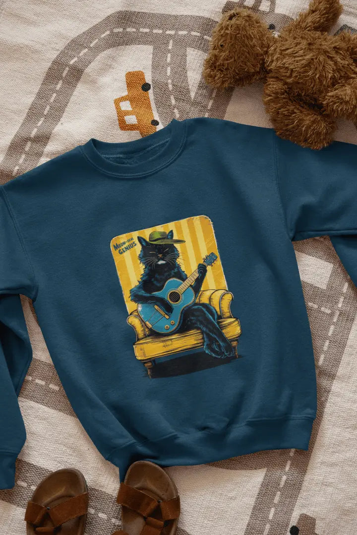 A navy blue printed sweatshirt with the design of a cat wearing a cute cap and playing a guitar while sitting on a sofa. The sweatshirt is lying down on the floor. There’s a text saying meowsical genius.
