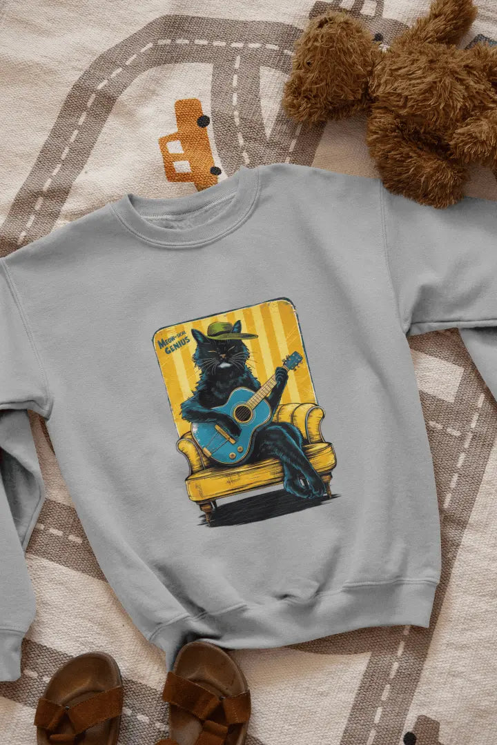 A melange grey printed sweatshirt with the design of a cat wearing a cute cap and playing a guitar while sitting on a sofa. The sweatshirt is lying down on the floor. There’s a text saying meowsical genius.
