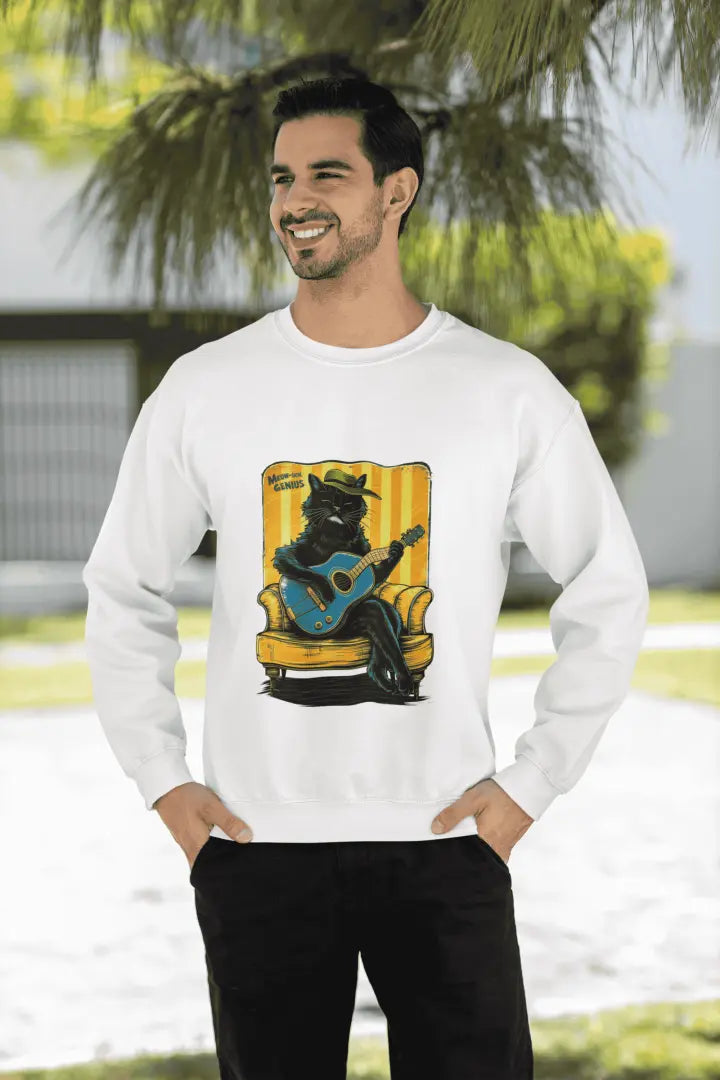 A man wearing a white printed sweatshirt with the design of a cat wearing a cute cap and playing a guitar while sitting on a sofa. There’s a text saying meowsical genius.