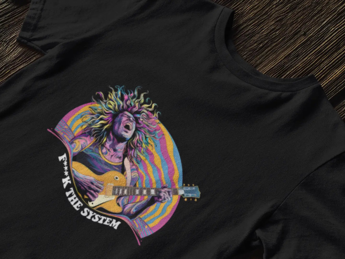 A printed black T-shirt lying down on a table. The design consists of a man playing guitar in feel. There’s a text saying F**k the system on the bottom of the design.