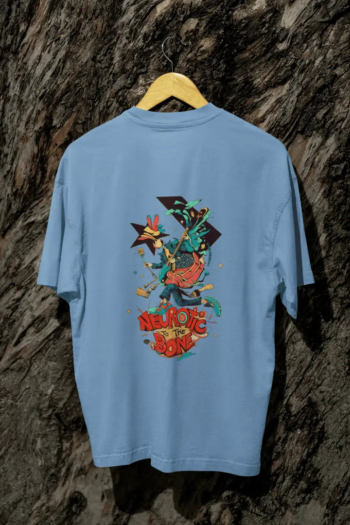 A baby blue back printed oversized T-shirt with a hanging against a tree trunk. The T-shirt design contains of a funky character with an instrument and a microphone in his hand. There’s a text saying “Neurotic to the bone”.