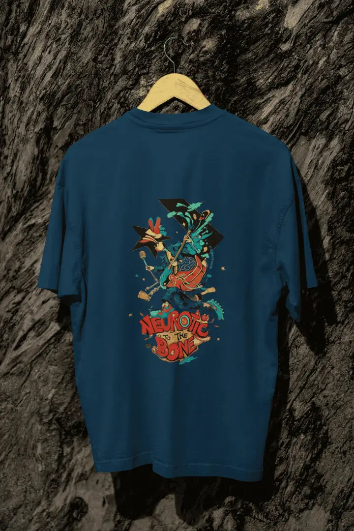 A navy blue back printed oversized T-shirt with a hanging against a tree trunk. The T-shirt design contains of a funky character with an instrument and a microphone in his hand. There’s a text saying “Neurotic to the bone”.
