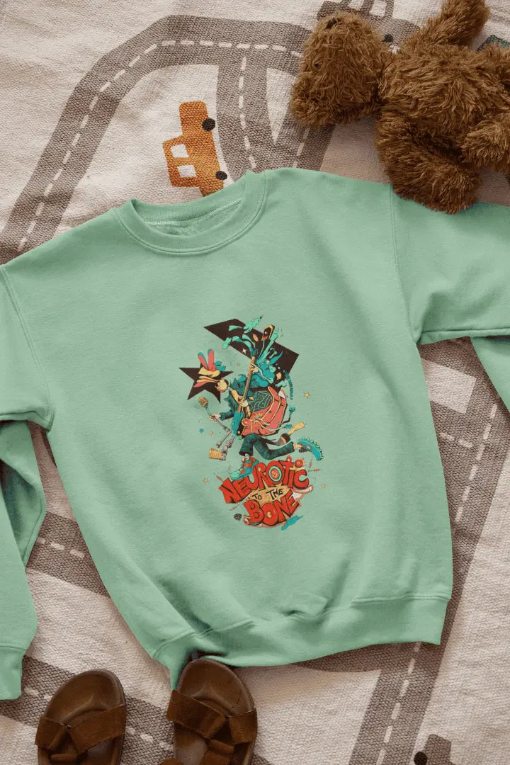 A green sweatshirt with a printed design lying on the floor. The design contains of a funky character with an instrument and a microphone in his hand. There’s a text saying “Neurotic to the bone”.