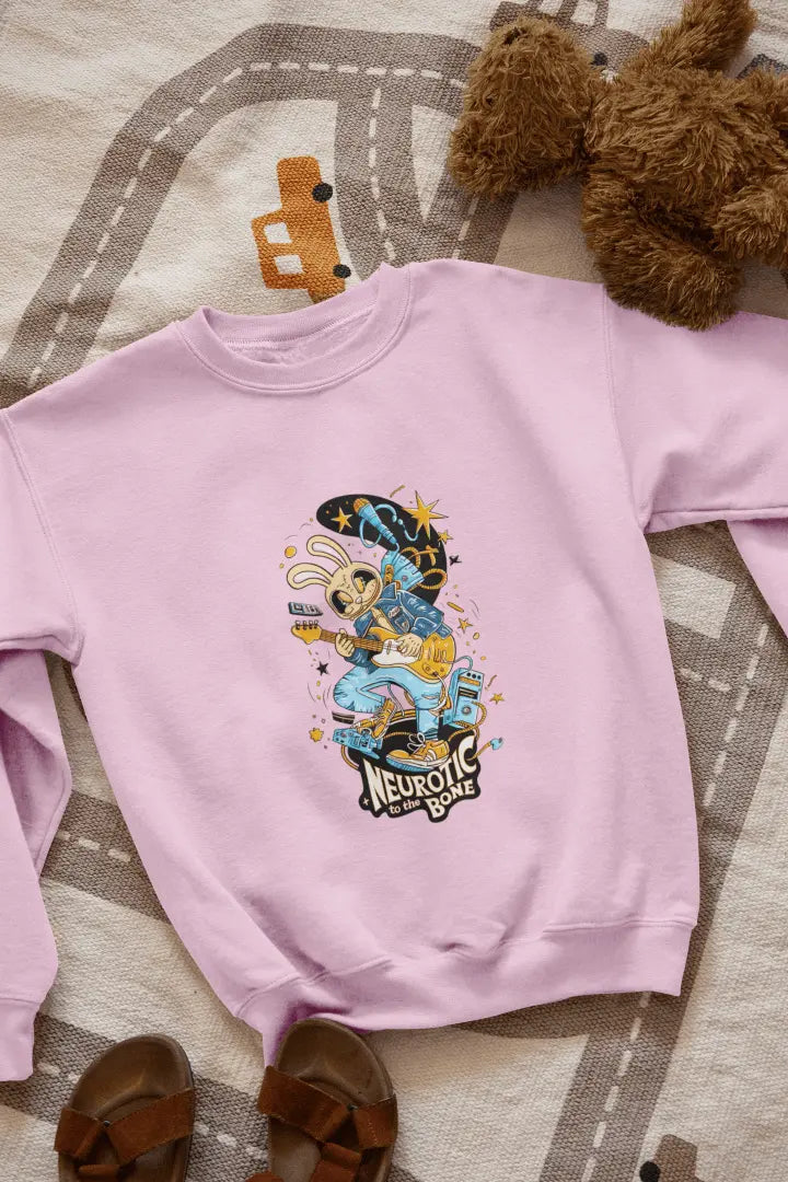 A pink sweatshirt with a printed design lying on the floor. The design contains of a funky character playing a guitar. There’s a text saying “Neurotic to the bone” at the bottom of the design.