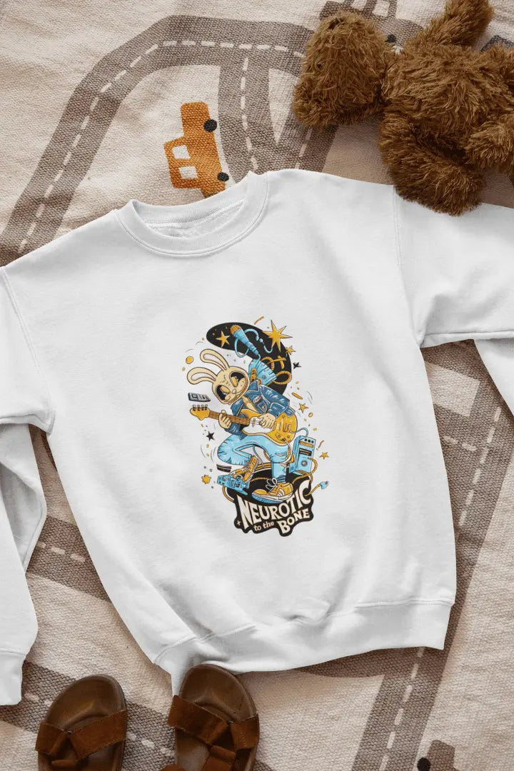 A white sweatshirt with a printed design lying on the floor. The design contains of a funky character playing a guitar. There’s a text saying “Neurotic to the bone” at the bottom of the design.