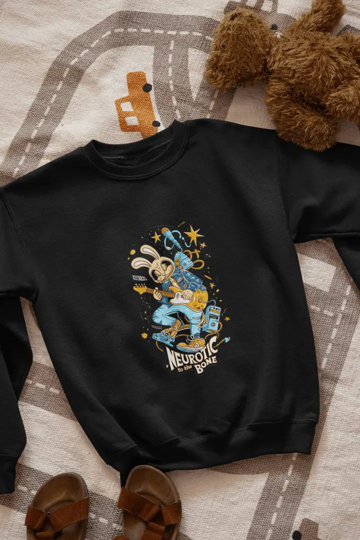 A black sweatshirt with a printed design lying on the floor. The design contains of a funky character playing a guitar. There’s a text saying “Neurotic to the bone” at the bottom of the design.