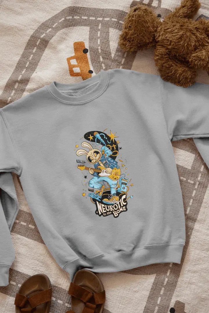 A melange grey sweatshirt with a printed design lying on the floor. The design contains of a funky character playing a guitar. There’s a text saying “Neurotic to the bone” at the bottom of the design.