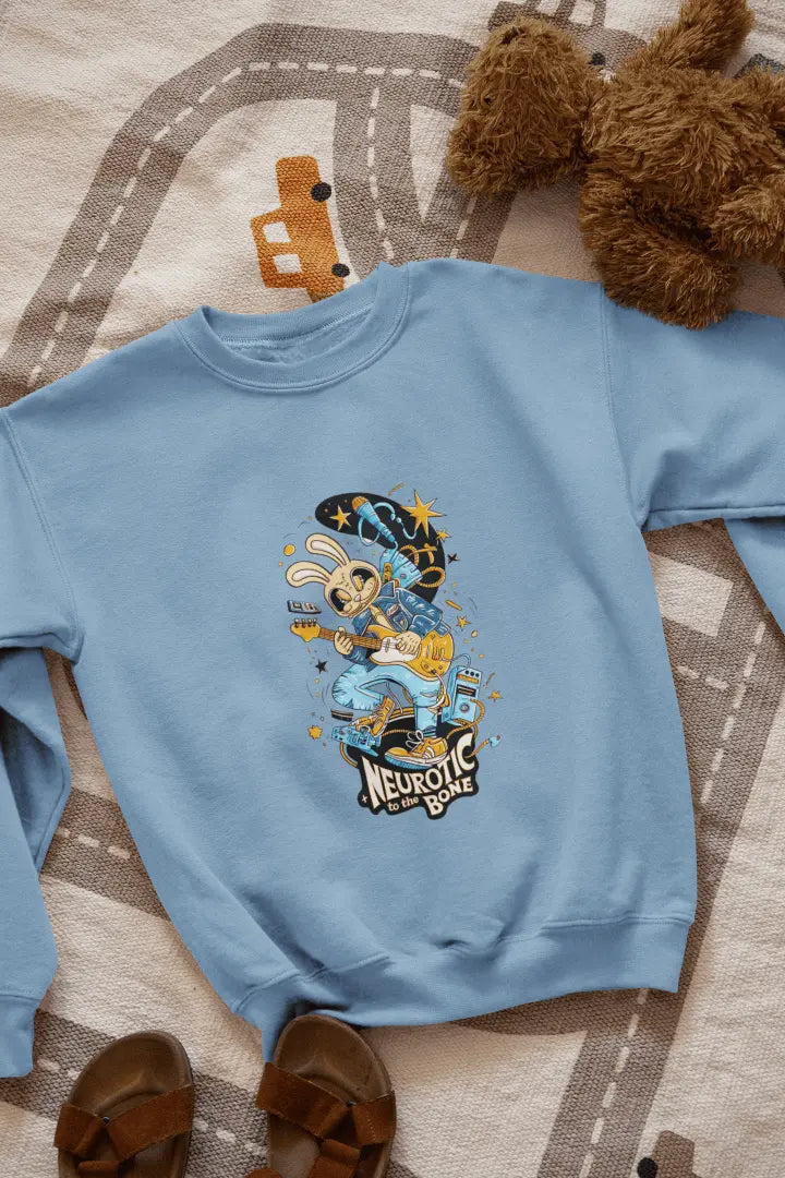 A baby blue sweatshirt with a printed design lying on the floor. The design contains of a funky character playing a guitar. There’s a text saying “Neurotic to the bone” at the bottom of the design.
