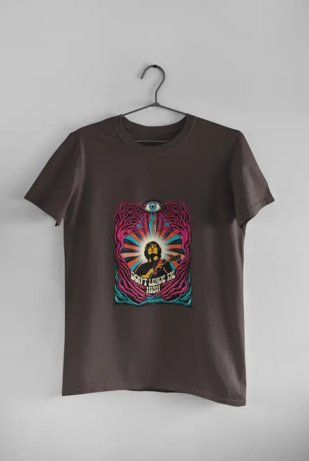 A charcoal grey t-shirt with a psychedelic design printed on the front hanging against a light grey wall. The design contains a man playing guitar with his eyes closed. The overall design is psychedelic with an eye at the top and a text saying Don't leave me high at the bottom of the design.