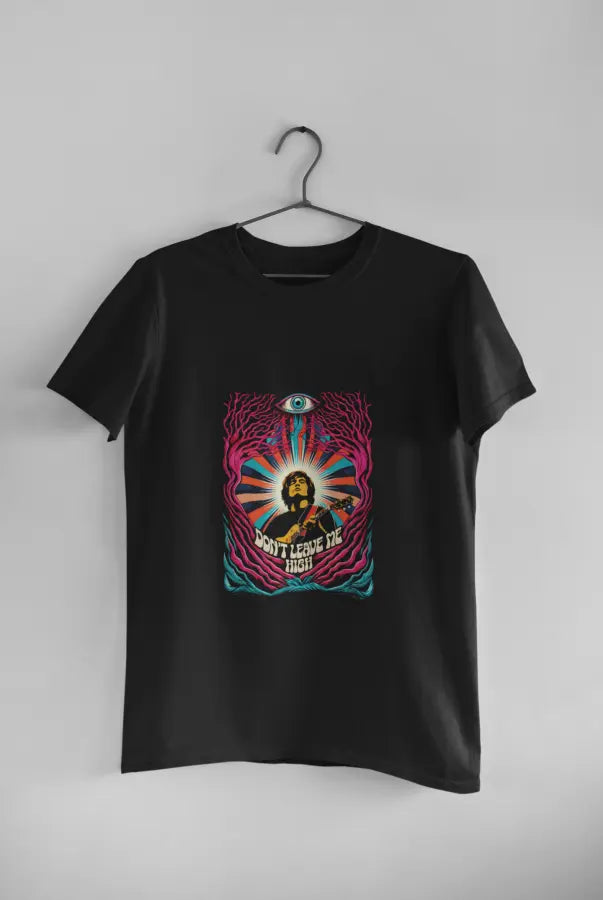 A black t-shirt with a psychedelic design printed on the front hanging against a light grey wall. The design contains a man playing guitar with his eyes closed. The overall design is psychedelic with an eye at the top and a text saying Don't leave me high at the bottom of the design.