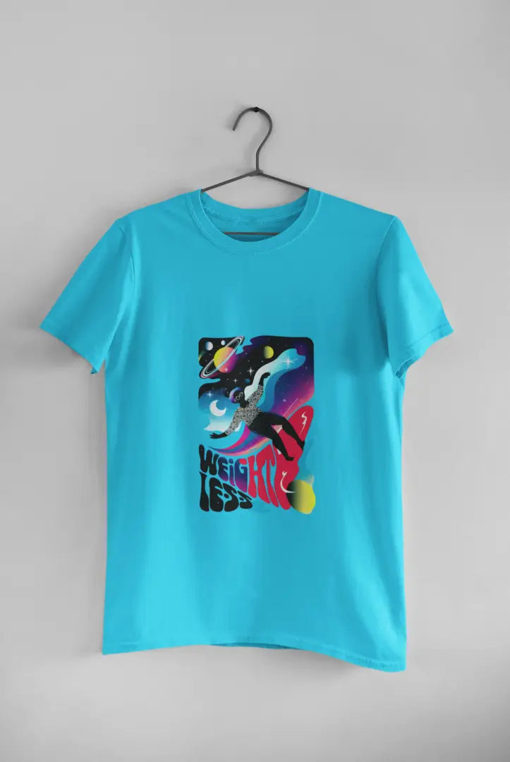 A blue t-shirt with a design printed on the front hanging against a light grey wall. The design contains a woman who is floating in space with planets and stars around her. There's a text saying Weightless at the bottom of the design.