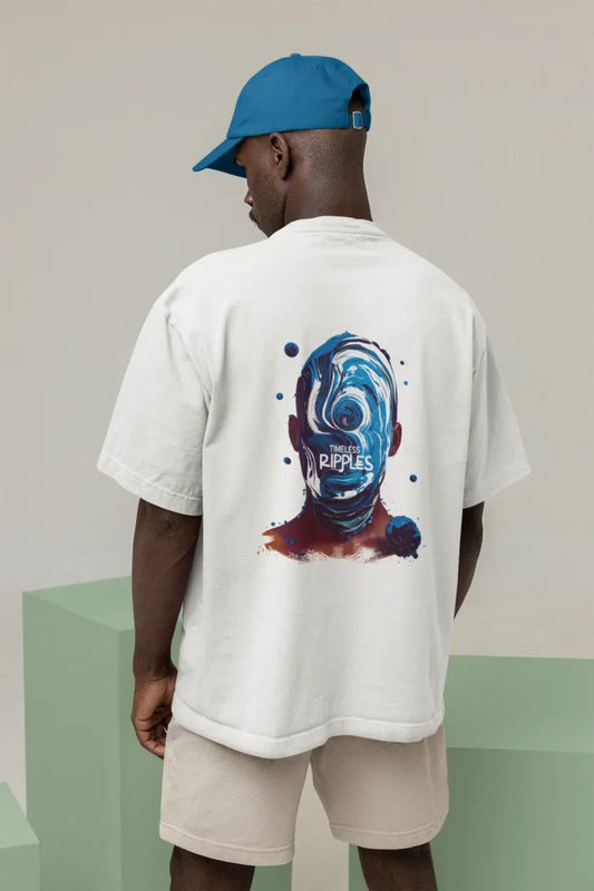 A man wearing a white oversized t-shirt with a design printed at the back. The design contains a character whose face is made out of ripples of wave. There's a text saying Timeless Ripples at the center of the design.