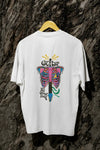 A white back printed oversized t-shirt with a psychedelic guitar design  hanging on a tree trunk