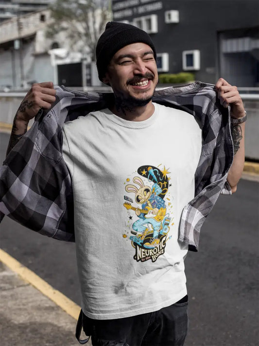 Young man wearing a white band T-shirt and a black beanie, standing in an empty parking lot with a building in the background. He is smiling widely and holding a black and white checkered shirt over his shoulders, looking happy and relaxed.