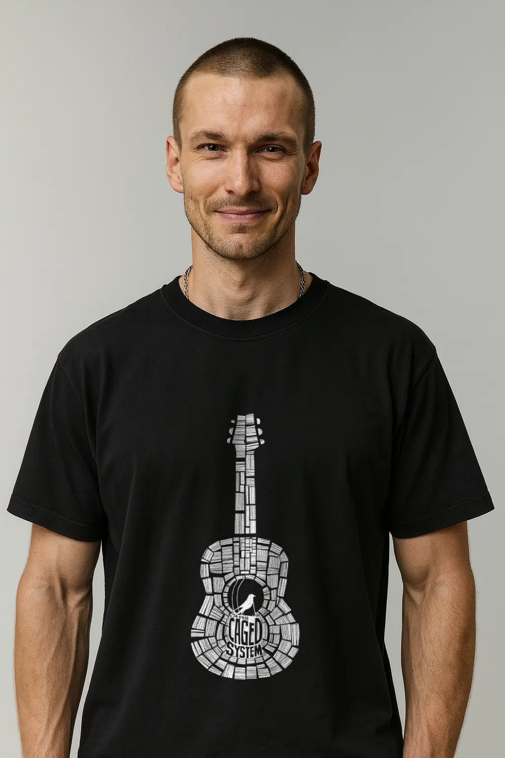 Man wearing a black t-shirt with a white guitar graphic on a gray background