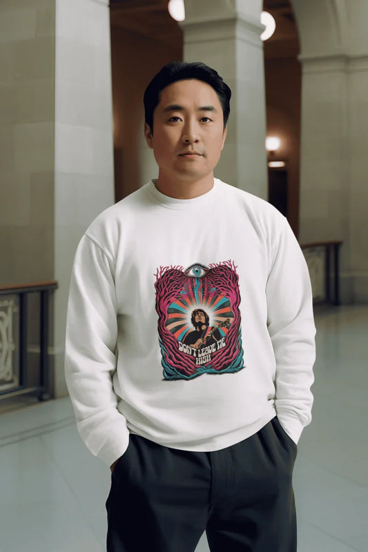 A man of Asian descent is centred in the image, wearing a white crew-neck sweatshirt with a vibrant psychedelic graphic. The design features a musician with the words “Don’t Leave Me Hush” in shades of magenta, teal, and orange. He has short, dark hair and a neutral expression, standing in black pants. 