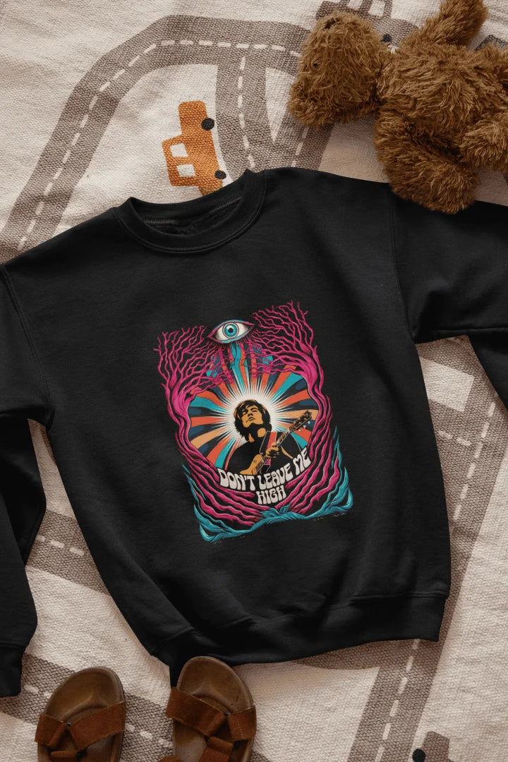 A black sweatshirt with a graphic print. The graphic features a young, light-skinned man, depicted from the mid-section up. He is playing a guitar. The man is positioned within an abstract design of swirling, colorful patterns and stylized,  leaf-like forms in various shades of pink, purple, teal, orange, and yellow. A large, stylized eye is prominently featured in the design, situated above the man's head. The words "DON'T LEAVE ME HIGH" are printed below.