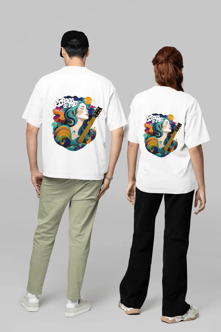 Two people wearing white oversized T-shirts with a vibrant graphic design on the back. The design features a young, light-skinned woman playing a guitar, depicted with flowing, colorful hair in a psychedelic and pop-art style.