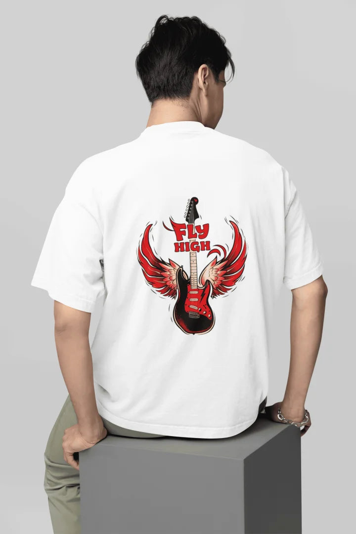 A man wearing back printed oversized t-shirt with a graphic featuring a stylized electric guitar with red flame-like wings. The words “FLY HIGH” are written in bold red above and below the guitar.