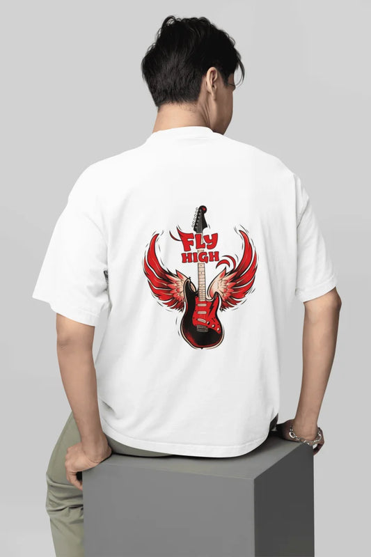 A man wearing back printed oversized t-shirt with a graphic featuring a stylized electric guitar with red flame-like wings. The words “FLY HIGH” are written in bold red above and below the guitar.
