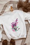 A white sweatshirt kept on the floor containing a psychedelic design pattern. The design contains of guitar made up of paint splashes, and a hand at the back, trying to grab it There is a text saying let me grab that neck.