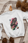 A printed white sweatshirt lying on the floor. The design of the sweatshirt contains of a man floating in space. The design is a colourful design with tiny planets and stars. There’s a text saying Lost in the sound.