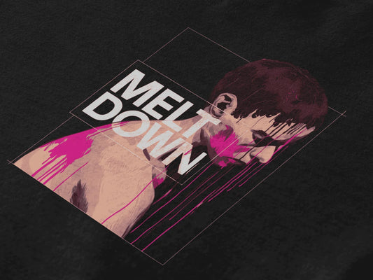 A black T-shirt lying down containing the design of a man in grief. The man is covered in pink paint splashes with paint dripping down from his face. There’s a text saying Meltdown on the design. 