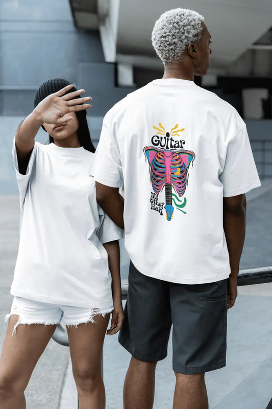 A man and a woman posing like models. The girl is wearing a plain white oversized t-shirt, the boy is wearing a white back printed oversized t-shirt with a psychedelic guitar design saying Guitar My Other Half.
