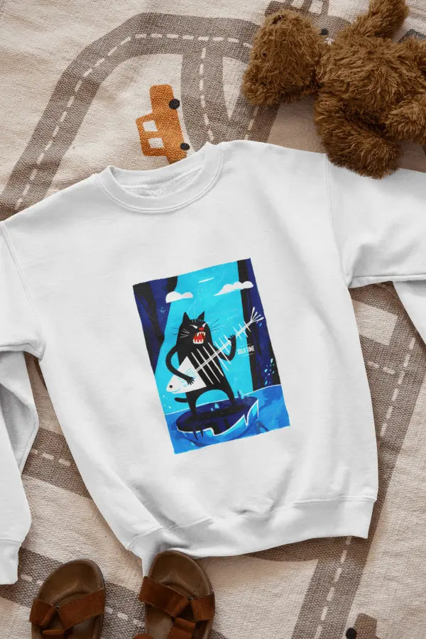 A white sweatshirt with a design printed on the front lying on the floor. The design contains a cat standing on an iceberg holding a fish bone which appears to be like a guitar. There's a text saying Solo Time on the right side.