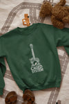 An olive green sweatshirt with a minimal design printed on the front lying on the floor. The design consists of an acoustic guitar inside which a small bird is sitting. There's a text saying The Caged System at the bottom of the design.
